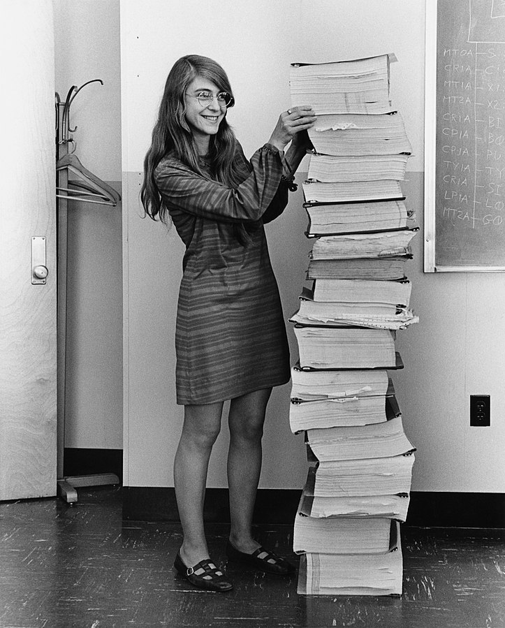 Margaret Hamilton, standing next to the software that she and her MIT team created for the Apollo project.